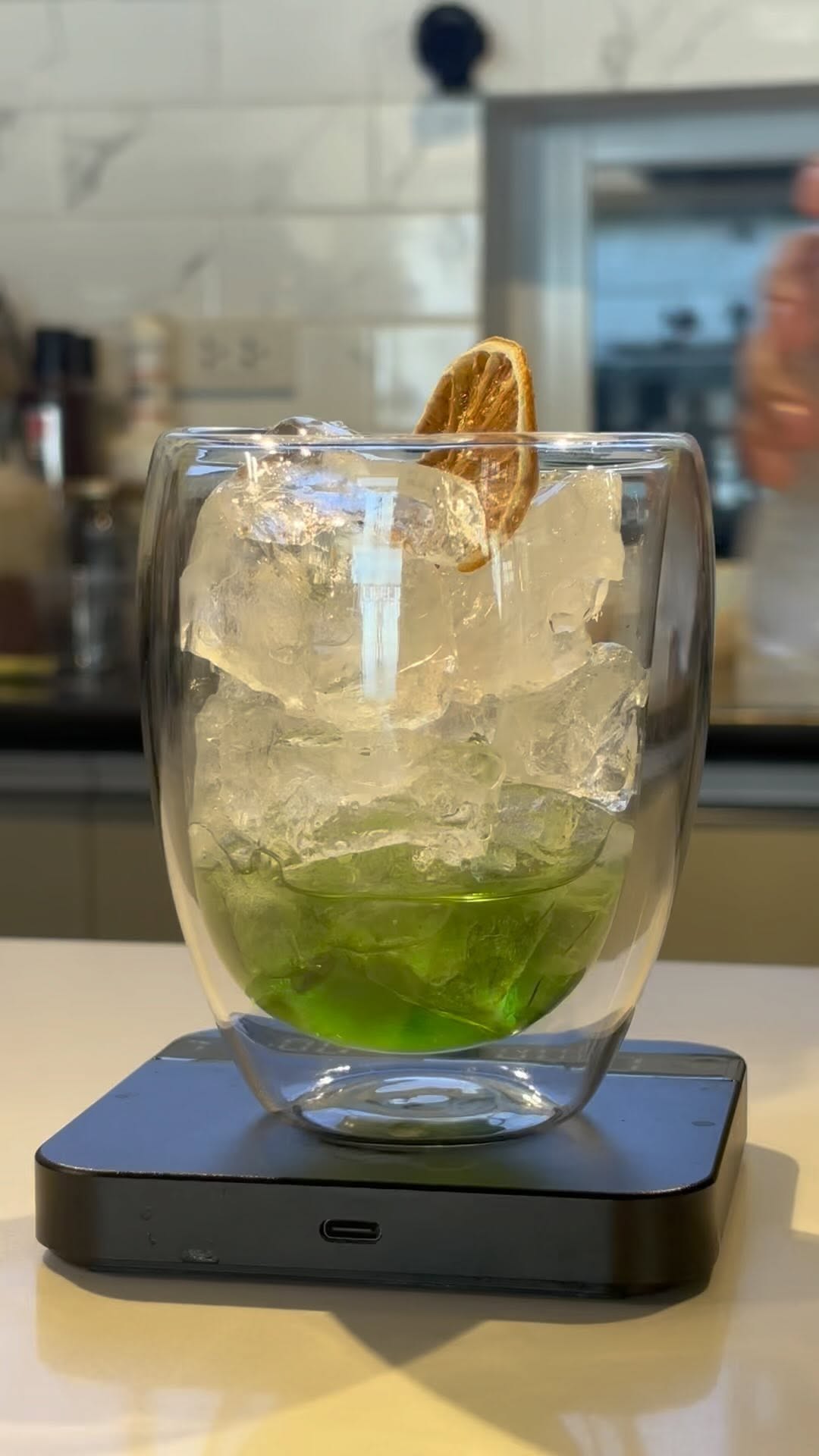 Blue Lagoon non-coffee drink in a double-wall glass with dehydrated lemon garnish